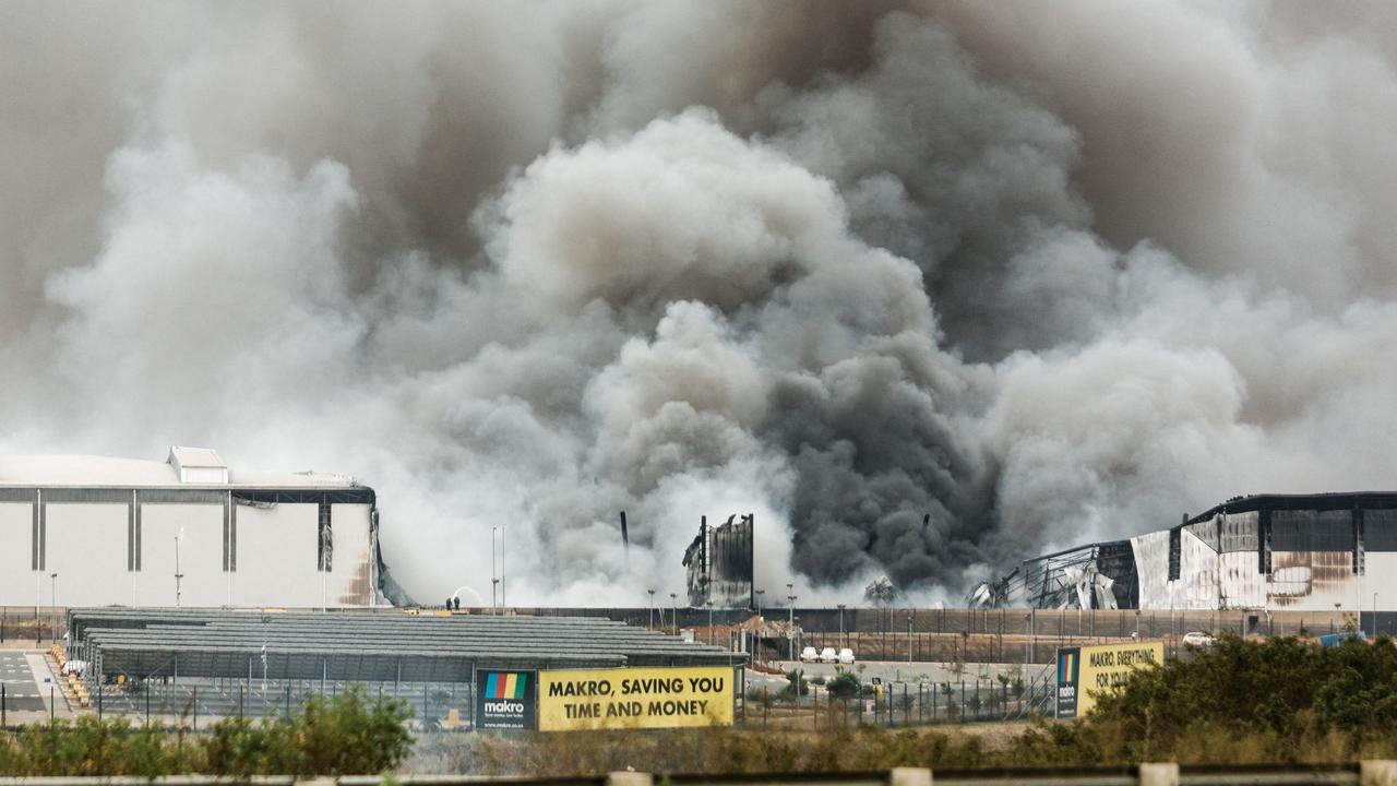 Smoke rises from a Makro building set on fire overnight in Umhlanga, north of Durban, as several shops, businesses and infrastructure are damaged in the city, following four nights of continued violence and looting sparked by the jailing of ex-president Jacob Zuma. Picture: AFP